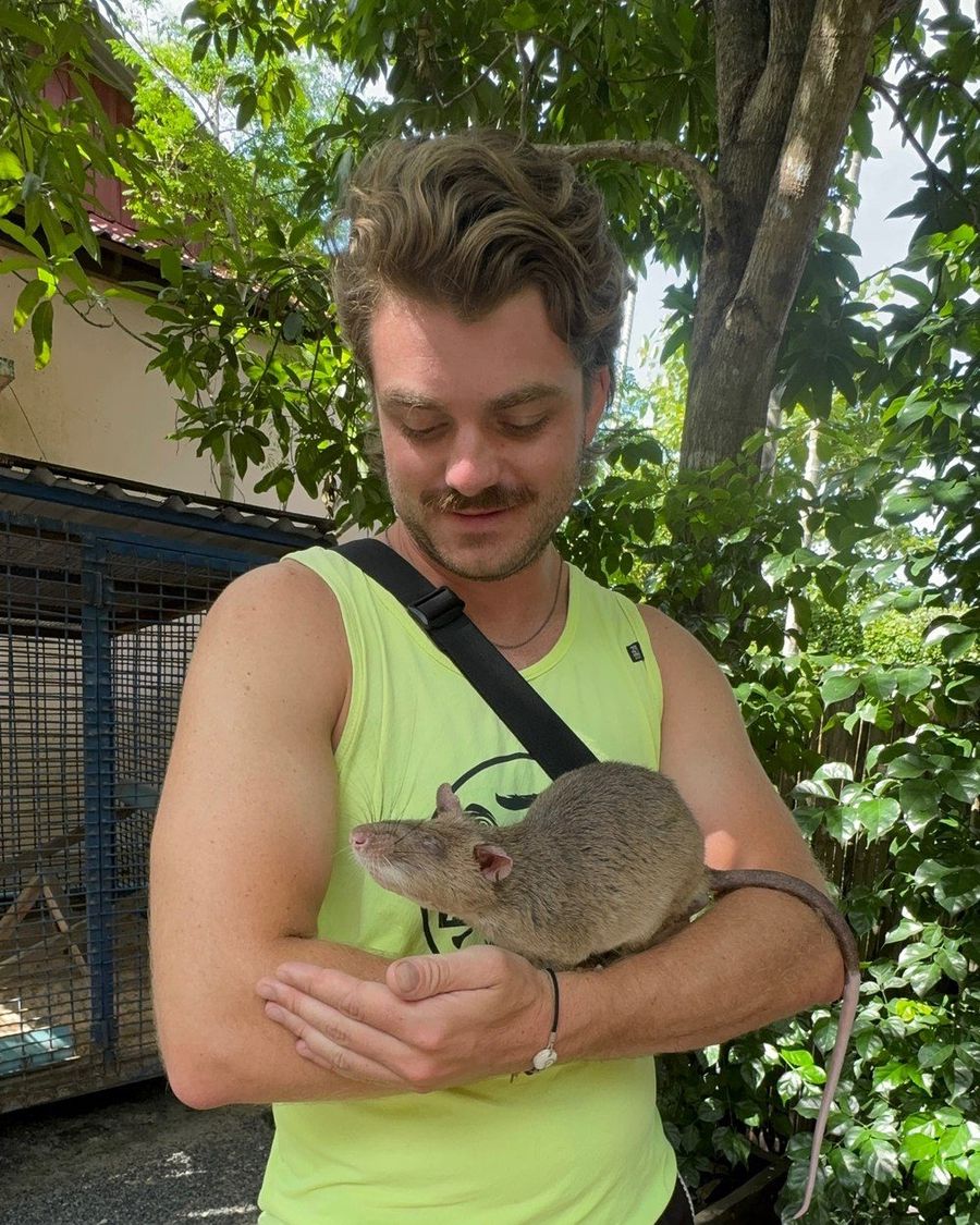 Ian holding a large pouched HeroRAT cradled in his arms, in Australia.